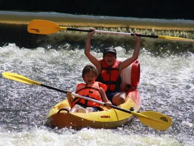 a man and a child in a kayak on a river at Camping Matyáš in Vrané nad Vltavou