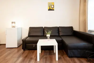 a living room with a black couch and a white table at Wow Wow Apartment in Prague
