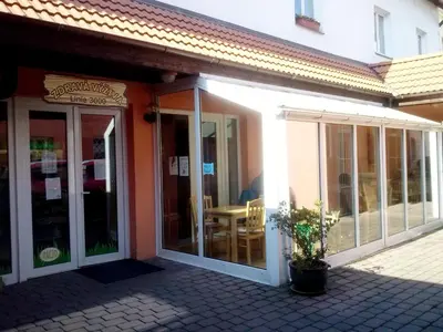 a building with sliding glass doors and a table at Wellness Hotel Svoboda in Rakovník