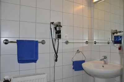 a bathroom with a sink and a phone on the wall at AeroRooms in Prague
