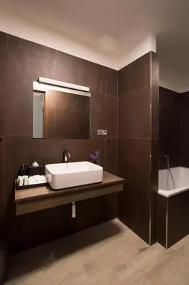a bathroom with a sink and a mirror and a tub at Areal Botanika in Unhošť
