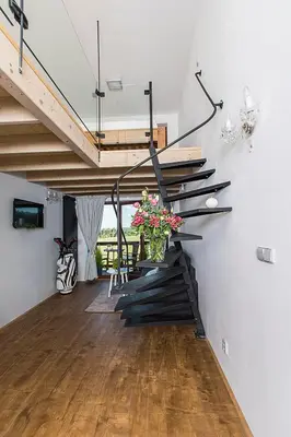 a staircase in a living room with a vase of flowers at Areal Botanika in Unhošť