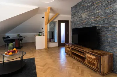 a living room with a large television on a brick wall at Areal Botanika in Unhošť