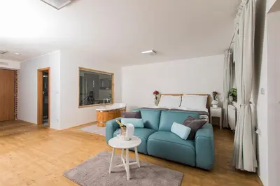 a living room with a blue couch and a table at Areal Botanika in Unhošť