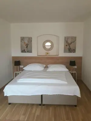 a bedroom with a large white bed and a mirror at Apartmány Sedmikráska in Tehovec