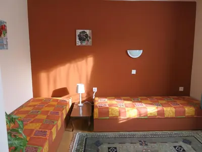 two beds in a room with orange walls at Apartmány Sedmikráska in Tehovec