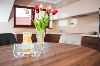 a vase of flowers sitting on a wooden table at POINT flat, beautiful view from terrace to Prague Castle in Prague