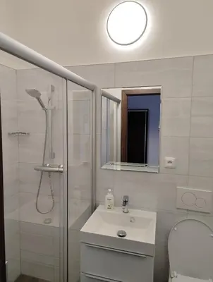 a white bathroom with a shower and a sink at Minihotel Vitex in Prague