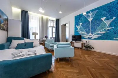a bedroom with a blue couch and a living room at Apartrezidence Opletalova in Prague
