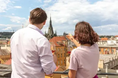 a man and a woman standing on a roof looking at a city at Miss Sophie's Downtown in Prague