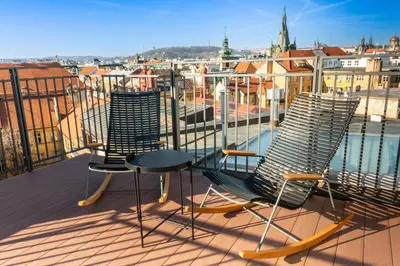 three chairs and a table on a balcony with a view at Miss Sophie's Downtown in Prague