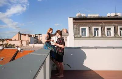 a man and woman standing on the ledge of a roof at Miss Sophie's Downtown in Prague