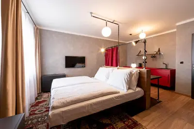 a bedroom with a large bed with a red curtain at Miss Sophie's Downtown in Prague
