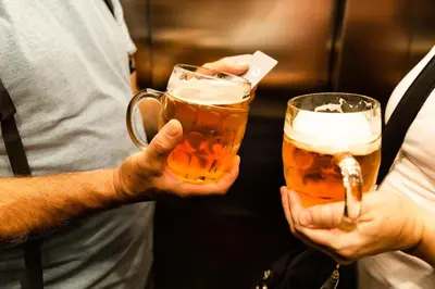 two people holding glasses of beer in their hands at Miss Sophie's Downtown in Prague