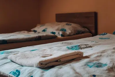 a bed with a towel on top of it at Penzion Na Vošverku in Čelákovice
