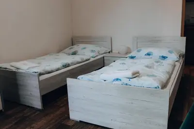 two twin beds in a room with wooden floors at Penzion Na Vošverku in Čelákovice