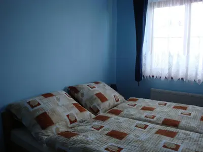 a bedroom with a bed with a quilt and a window at Pension Olga in Klecany