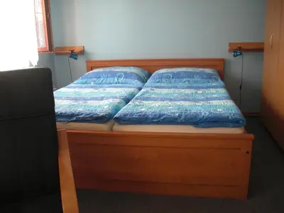 a bed with blue pillows on it in a room at Pension Olga in Klecany