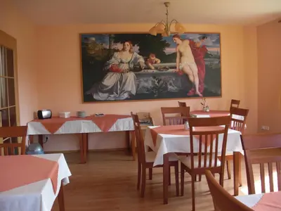 a dining room with two tables and a painting on the wall at Pension Olga in Klecany