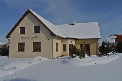 a house with snow on the ground in front of it at Pension Olga in Klecany