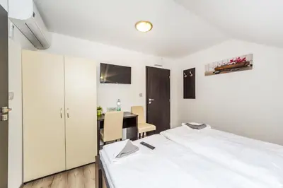 a bedroom with a white bed and a table at Nová Hospoda - Hotel & Restaurant in Prague