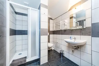 a bathroom with a sink and a toilet at Nová Hospoda - Hotel & Restaurant in Prague