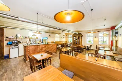 a restaurant with tables and chairs and a bar at Nová Hospoda - Hotel & Restaurant in Prague