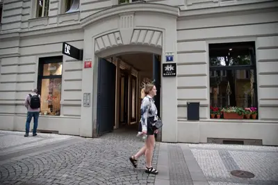 a woman walking down a street in front of a building at Apartment Tereza in Prague