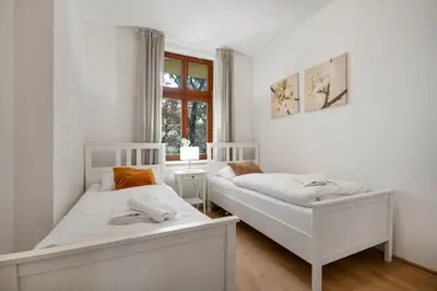 two white beds in a room with a window at Downtown Residence in Prague