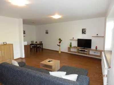 a living room with a blue couch and a tv at Penzion Linhart in Poděbrady