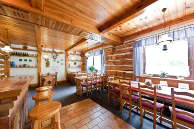 a restaurant with wooden walls and tables and chairs at Penzion Linhart in Poděbrady
