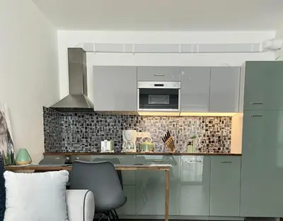 a kitchen with white cabinets and a table with a chair at New residence apartments near Wenceslas Square in Prague