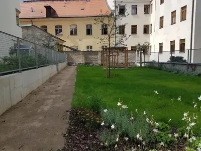 an empty yard with flowers in the grass at New residence apartments near Wenceslas Square in Prague