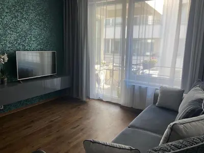 a living room with a couch and a television at New residence apartments near Wenceslas Square in Prague