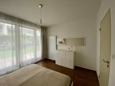 a white bedroom with a bed and a window at New residence apartments near Wenceslas Square in Prague