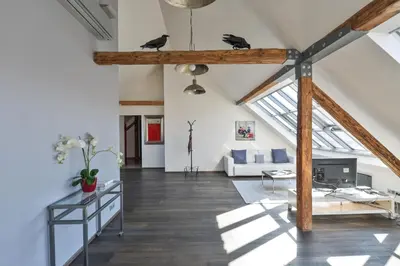 a living room with a vaulted ceiling with beams at Designer Loft in Prague