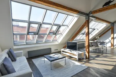 a living room with large windows and a white couch at Designer Loft in Prague