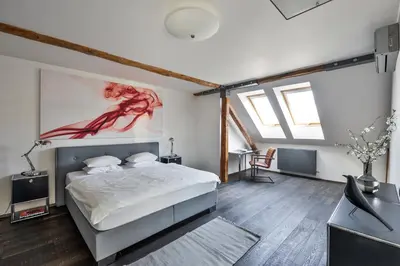 a bedroom with a bed and a painting on the wall at Designer Loft in Prague