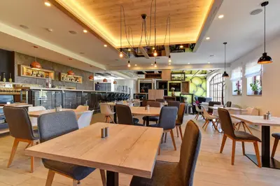 a dining room with wooden tables and chairs at Hotel Grunt in Mladá Boleslav