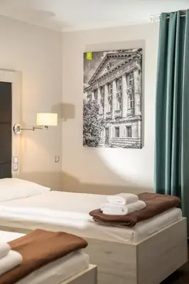 a bedroom with two beds and a painting on the wall at Hotel Grunt in Mladá Boleslav