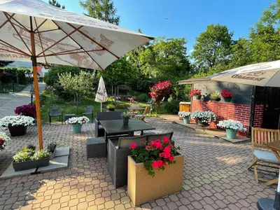 a patio with an umbrella and tables and flowers at HOTEL DIANA apartments in Prague