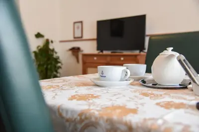 a table with two cups and a teapot on it at HOTEL DIANA apartments in Prague
