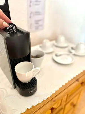 a coffee maker on a counter with a cup on it at HOTEL DIANA apartments in Prague