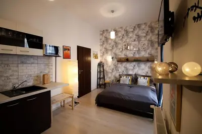 a bedroom with a bed and a kitchen with a sink at Snajder Apartment, 15min to Old Centre, Self-check in, Free Wifi in Prague