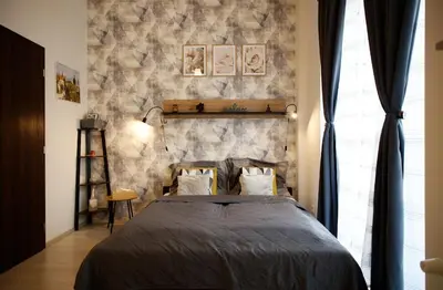 a bedroom with a bed and a stone wall at Snajder Apartment, 15min to Old Centre, Self-check in, Free Wifi in Prague