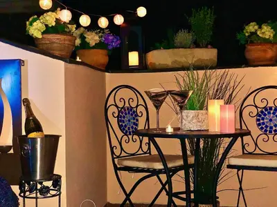 a table and chairs with flowers and a shelf with plants at Duplex with quite terrace on Wenceslas sq. in Prague