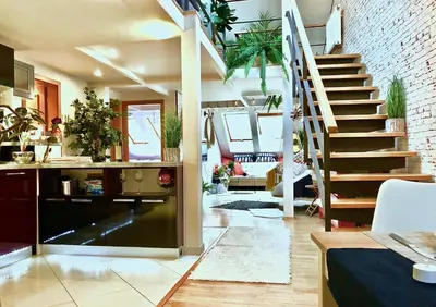 a living room with a spiral staircase in a house at Duplex with quite terrace on Wenceslas sq. in Prague