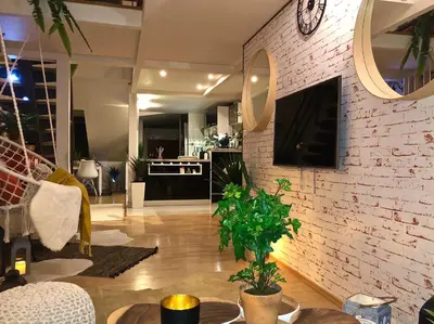 a living room with a clock on a brick wall at Duplex with quite terrace on Wenceslas sq. in Prague