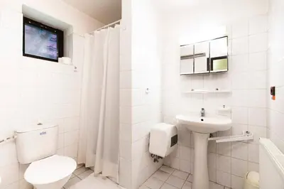 a white bathroom with a toilet and a sink at Pension U Dvou čápů in Chocerady