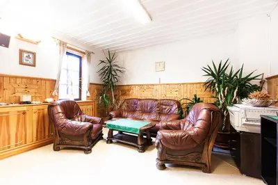 a living room with leather chairs and a piano at Pension U Dvou čápů in Chocerady